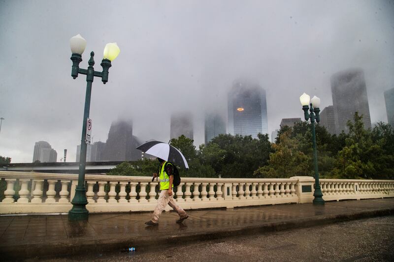 23. Houston, US: A pedestrian walks on the Sabine Street Bridge with the Houston skyline in the background. Photo: AP