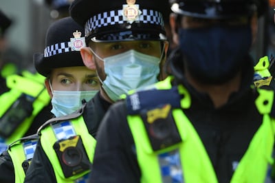 Police officers wearing protective face coverings to combat the spread of the coronavirus, arrive to disperse the crowd of demonstrators protesting against the Police, Crime, Sentencing and Courts Bill 2021 after they block the trams in central Manchester on May 1, 2021. Previous "Kill the Bill" demonstrations have turned violent, with protesters demanding the withdrawal of the legislation, which critics say harshly restricts the right to peaceful protest. / AFP / Oli SCARFF
