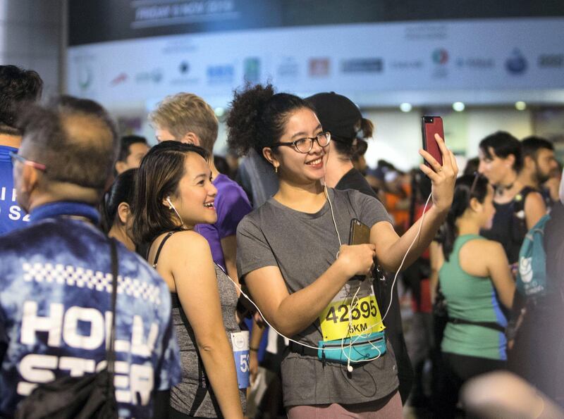 Dubai, United Arab Emirates - Participants before the run doing selfie  at the Dubai 30x30 Run at Sheikh Zayed Road.  Leslie Pableo for The National