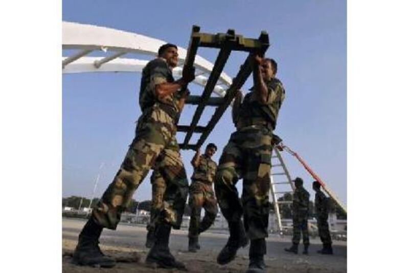 Indian soldiers work to rebuild the collapsed pedestrian bridge outside the Jawaharlal Nehru Stadium. Adnan Abidi / Reuters