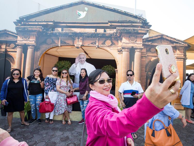 DUBAI, UNITED ARAB EMIRATES -Faithfuls doing selfies at Pope image at St. Mary's Catholic Church, Oud Mehta.  Leslie Pableo for The National for Anam Rizvi's story