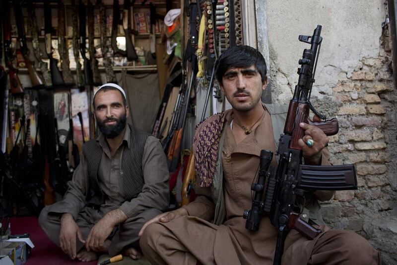 Gun vendors sit for a photograph while waiting for customers at their stall in a market in Kabul on October 21. Victor J. Blue/Bloomberg