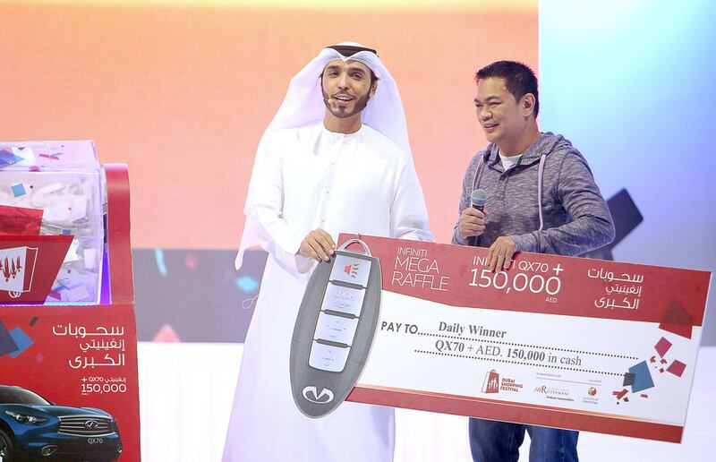 Joel Gutierrez collects his prize – the keys to a new Infinity QX70 and Dh150,000 in cash, at the Dubai Shopping Festival. Courtesy DSF