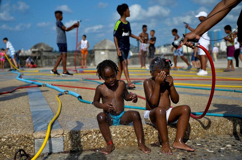 Children play with hoses as part of an art installation. AFP