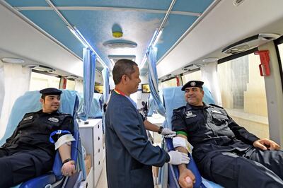 Police officers speak to a medic as they give blood in Abu Dhabi on Thursday. Hospitals say they need more members of the public to do the same. Courtesy: AD Police