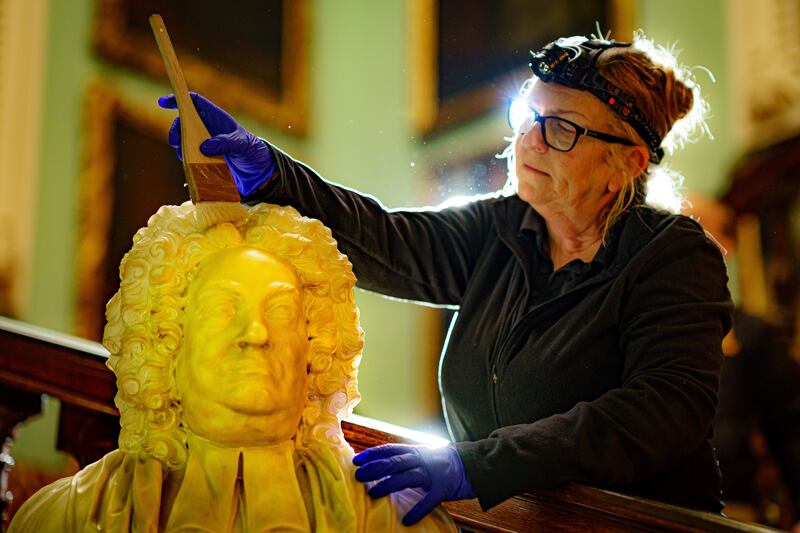 Conservation cleaner Tracie Mason dusts a marble bust of the Rev George Harbin on Wednesday in the Grand Staircase at Longleat House in Wiltshire, ensuring the stately home would be ready to start welcoming visitors again on April 1 after a two-year absence. PA