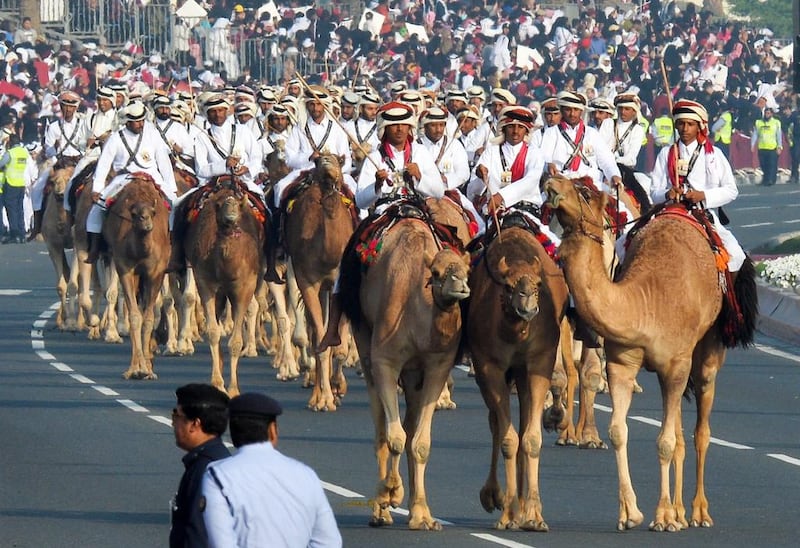 Qatari Heritage Police ride camels.