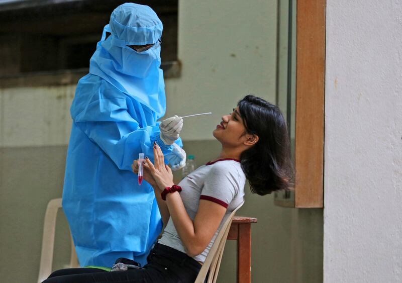 A student reacts as a health worker takes a nasal swab sample from her for COVID-19 test at St. Joseph's College in Bengaluru, India. A country of nearly 1.4 billion people, India is the world's second most coronavirus affected country after the United States. Colleges in Bengaluru are scheduled to reopen Tuesday.  AP Photo