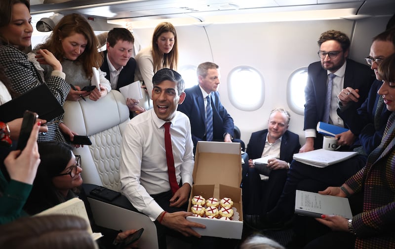 Mr Sunak presents cupcakes to journalists on board a plane on the way to Warsaw in April 2024. Getty Images