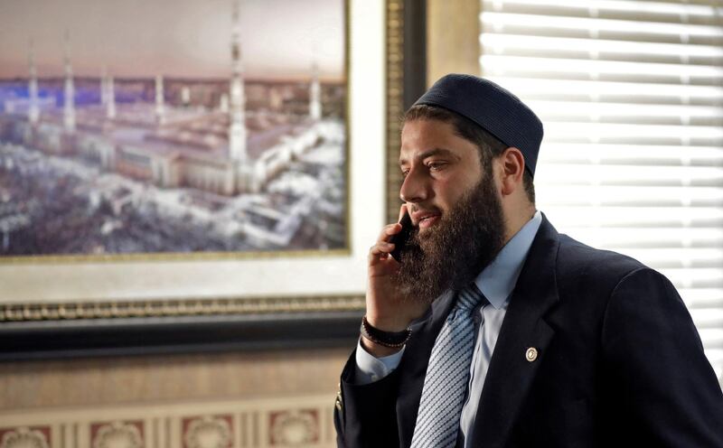 Hassan Shibly, attorney for Hoda Muthana, the Alabama woman who left home to join the Islamic State group in Syria, speaks on a phone before a news conference Wednesday, Feb. 20, 2019, in Tampa, Fla. United States Secretary of State Mike Pompeo said Muthana is not a U.S. citizen and will not be allowed to return to the United States. (AP Photo/Chris O'Meara)