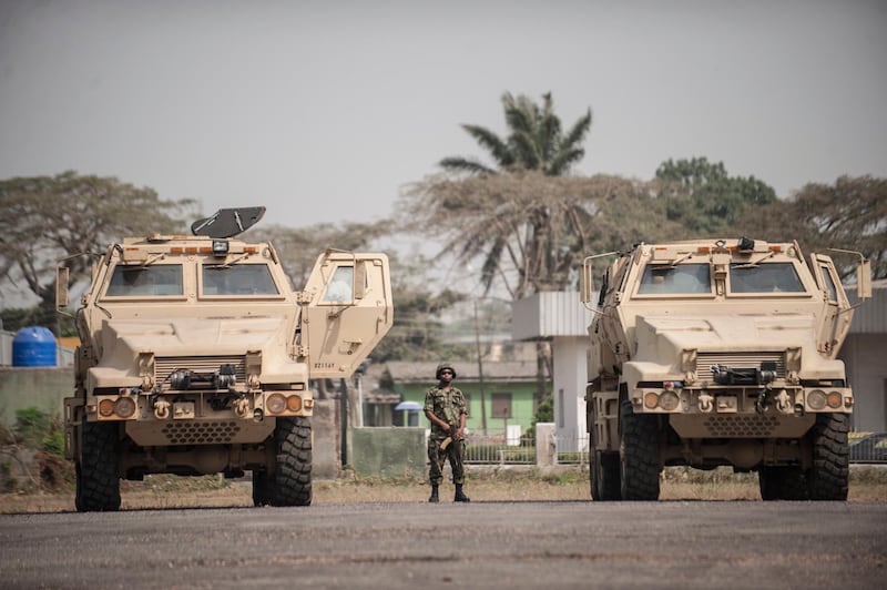 A Nigerian soldier stands between the 24 armoured vehicles donated by the United States to the Nigerian military at the Nigerian Army 9th Brigade Parade Ground in Lagos on January 7, 2016. - The U.S. government donated the vehicles to help fight Boko Haram, an extremist group whose six-year insurgency has killed over 17,000 people. (Photo by STEFAN HEUNIS / AFP)