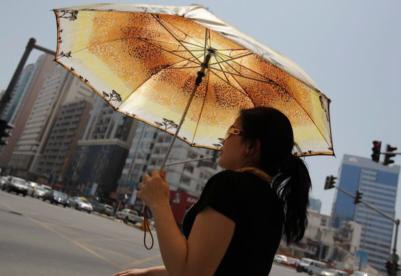 ABU DHABI, UNITED ARAB EMIRATES - May 30, 2009: A lady takes refuge from the sun with an umbrella, it was a hot day today in Abu Dhabi. ( Ryan Carter / The National )

*** stock, hot, heat, weather, sun,  *** Local Caption ***  RC008-HeatHot.JPGRC008-HeatHot.JPGRC008-HeatHot.JPG