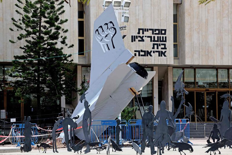 An installation of a crushed Israeli Air Force fighter jet is displayed during a protest against the government's judicial reform bill. AFP