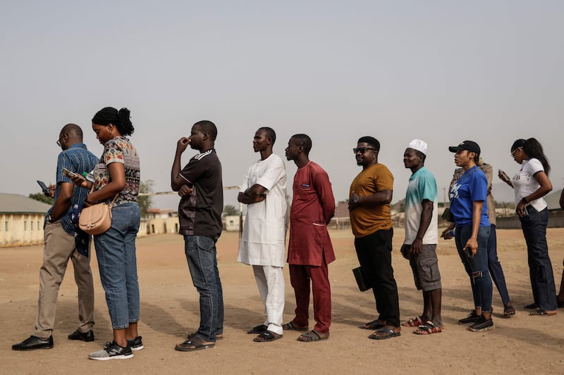 People queue to write their names on an unofficial list of  voters in Abuja. AFP