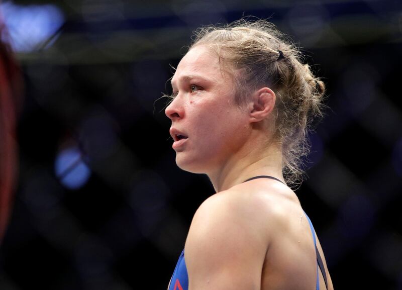 FILE - In this Dec. 30, 2016, file photo, Ronda Rousey stands in the cage after Amanda Nunes forced a stoppage in the first round of their women's bantamweight championship mixed martial arts bout at UFC 207 in Las Vegas. The former UFC champion Rousey could soon make the move to WWE. Sheâ€™s met with WWE executives and has seemed excited about the possibility of becoming a wrestler. Rousey may not debut at one of WWEâ€™s signature events this weekend in Philadelphia because sheâ€™s filming a movie in Colombia. (AP Photo/John Locher, File)