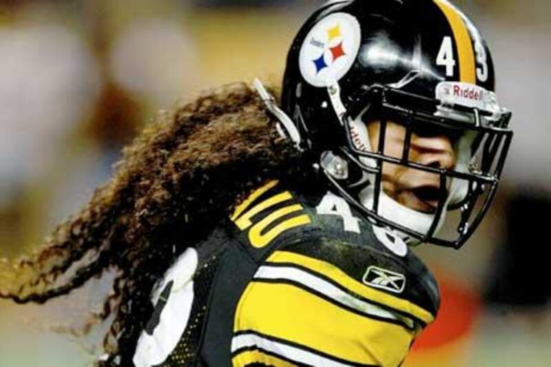 With his hair flying behind him, the Pittsburgh Steelers' Troy Polamalu runs the ball against the Tennessee Titans.