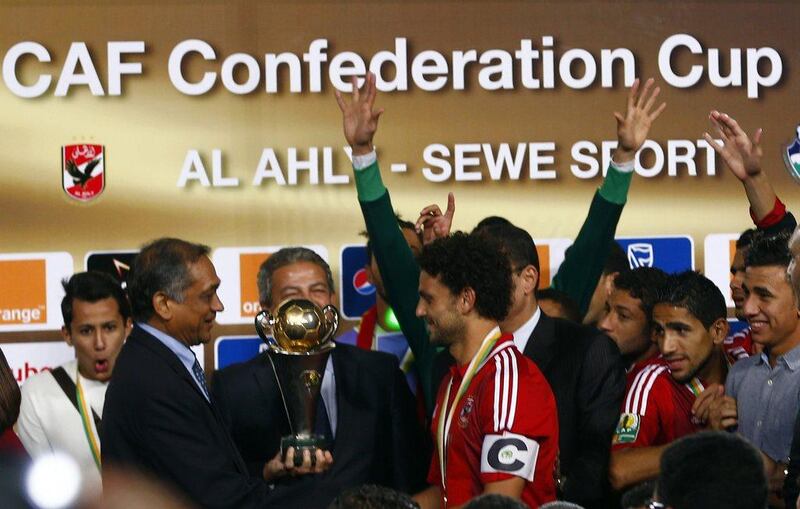 Egypt's Al Ahly captain Hossam Ghaly. right, receives the trophy for the club's victory in the CAF Confederation Cup final on Saturday in Cairo. Amr Abdallah Dalsh / Reuters
