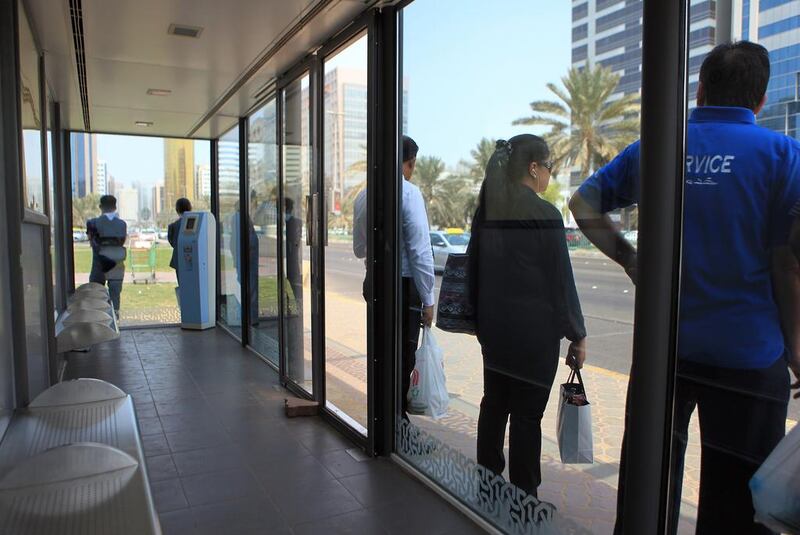 Commuters stand outside a bus stop with faulty air-conditioning near Madinat Zayed on Muroor Road.  Ravindranath K / The National