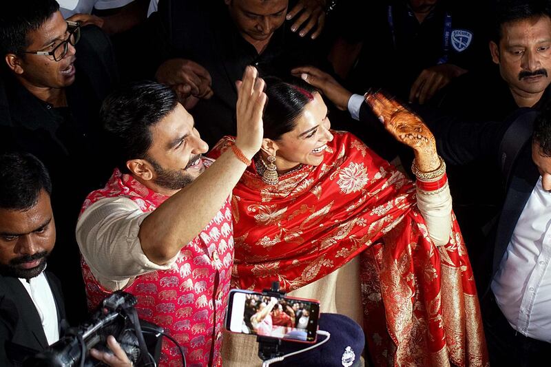 Bollywood actors and recently-wedded couple Ranveer Singh (L) and Deepika Padukone acknowledge fans gathered at the Mumbai international airport early on November 18, 2018, following their return from their nuptials at Italy's Lake Como.  Photo / AFP