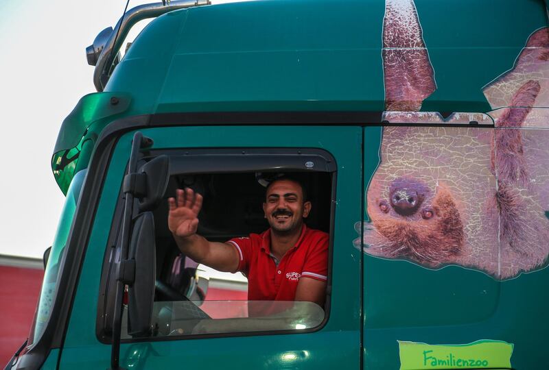 An Egyptian lorry driver waves to Palestinian people after arriving at Rafah border crossing. More than 120 Egyptian aid trucks brought aid from Egypt to the Gaza Strip.  EPA