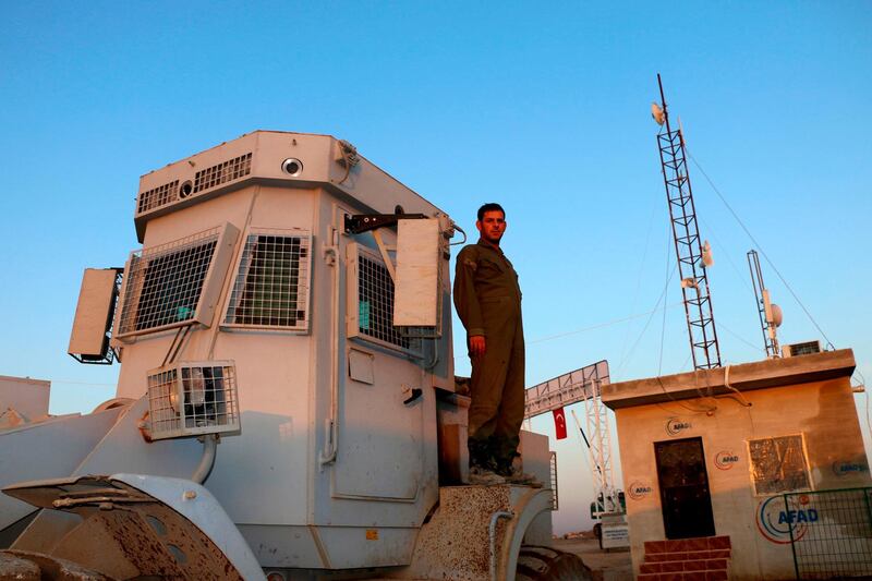 A Turkish soldier stands atop a bulldozer at the Deir al-Ballut refugee camp in Afrin, Syria. AFP