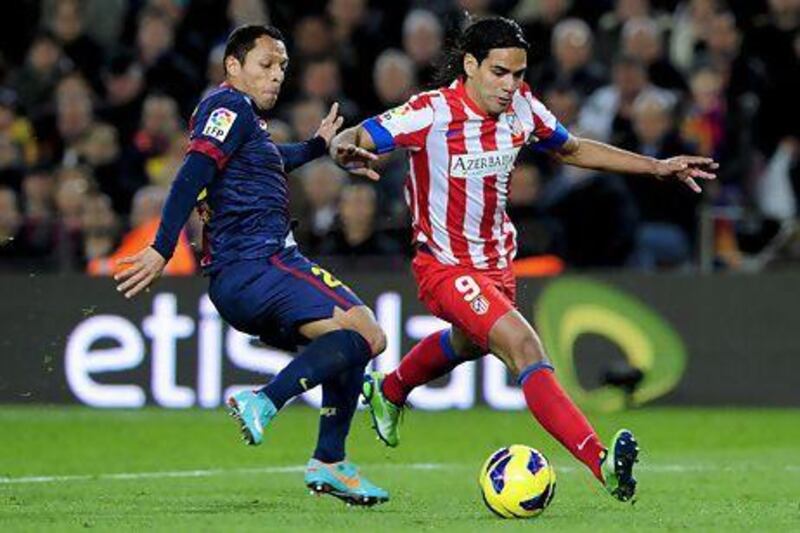 Barcelona's Adriano Correia, left, takes on Atletico Madrid's Radamel Falcao Garcia at the Camp Nou stadium in Barcelona. Etisalat has extended its sponsorship of FC Barcelona for another four years. Josep Lago / AFP