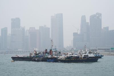 Buildings stand shrouded beyond anchored boats in Singapore, on Wednesday, Sept. 18, 2019. The air quality level in Singapore turned unhealthy ahead of the Formula 1 race this weekend, while Kuala Lumpur was ranked among the world’s most polluted cities, as wind from neighboring Indonesia continued to sweep in ash and smoke from illegal burning of forests and farm land. Photographer: Dimas Ardian/Bloomberg