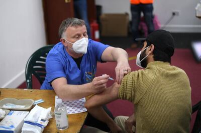 Members of the public receive a dose of the AstraZeneca/Oxford vaccine at a coronavirus vaccination centre at the Fazl Mosque in southwest London on March 23, 2021, on the first anniversary of the first national Covid-19 lockdown.  / AFP / DANIEL LEAL-OLIVAS
