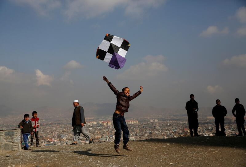 An Afghan boy launches a kite as he plays on top of a hill in Kabul. Mohammad Ismail / Reuters
