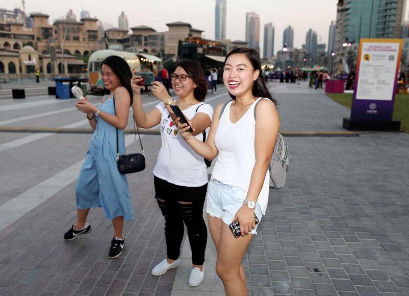 Dubai, United Arab Emirates - October 20, 2019: Visitors laugh at the One year to go celebrations. Sunday the 20th of October 2019. Burj Park, Dubai. Chris Whiteoak / The National