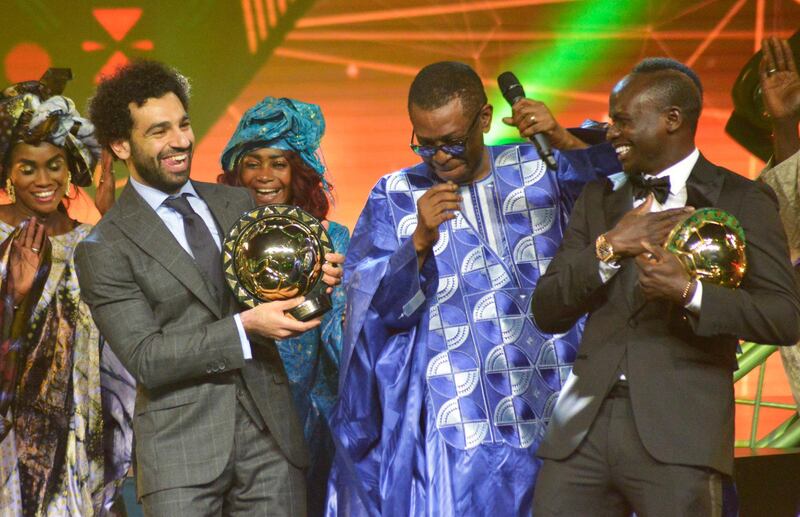 epa07270314 Mohamed Salah from Egypt (L) receives the Player of the Year award with runner up Sadio Mane from Senegal (R) with Senegalese singer Youssou Ndour (C) during the Confederation of African Football (CAF) awards at the Abdou Diouf International Conference Center in Dakar, Senegal, 08 January 2019.  EPA/STR