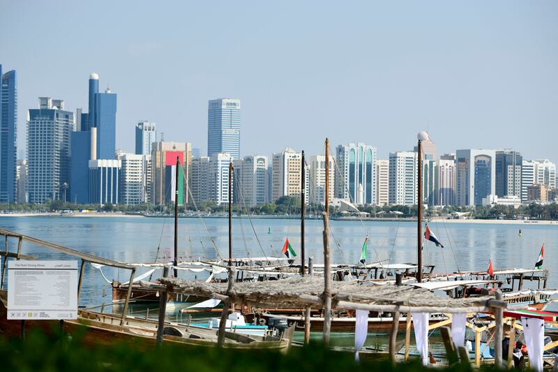 Dhows and other boats decked out in UAE flags, by the Heritage Village. Khushnum Bhandari / The National

