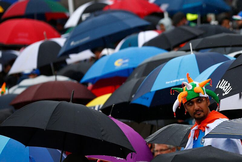 An India fan stands amongst umbrellas as rain delays the start of their ICC Champions Trophy final match against England at Edgbaston cricket ground in Birmingham, central England, June 23, 2013. REUTERS/Darren Staples   (BRITAIN - Tags: SPORT CRICKET) *** Local Caption ***  DST01_CRICKET-CHAMP_0623_11.JPG