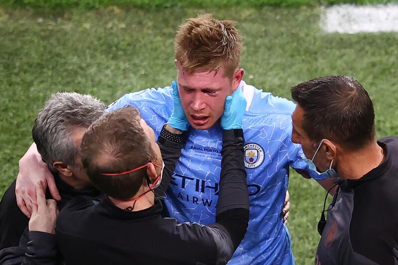 TOPSHOT - Manchester City's Belgian midfielder Kevin De Bruyne (C) receives treatment on the sidelines during the UEFA Champions League final football match between Manchester City and Chelsea at the Dragao stadium in Porto on May 29, 2021. / AFP / POOL / MICHAEL STEELE
