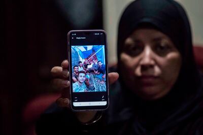 Egyptian Rawya Abdalla shows a phone picture of her relatives, who are among 17 Egyptians that went missing in Libya while trying to get to Europe, during an interview at the Dahmasha village in the Sharkia governorate, 60Km northeast of the capital, on September 23, 2020. Thousands of desperate migrants bound for Europe have perished in the Mediterranean Sea. In one impoverished Egyptian town, families fear that 15 of their sons are among the dead. / AFP / Khaled DESOUKI
