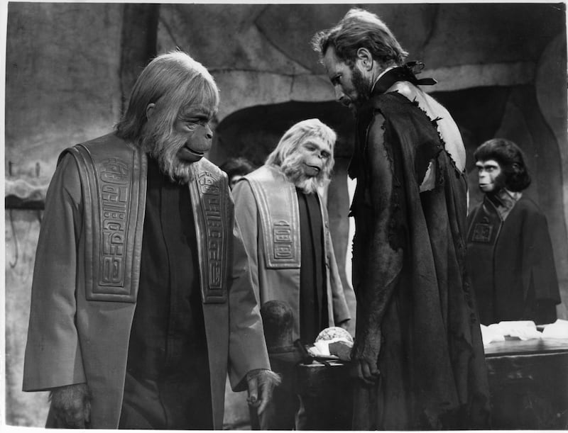 Maurice Evans makes a side remark to Charlton Heston, with unidentified council member and Kim Hunter in the background in a scene from the film 'Planet Of The Apes', 1968. (Photo by 20th Century-Fox/Getty Images)