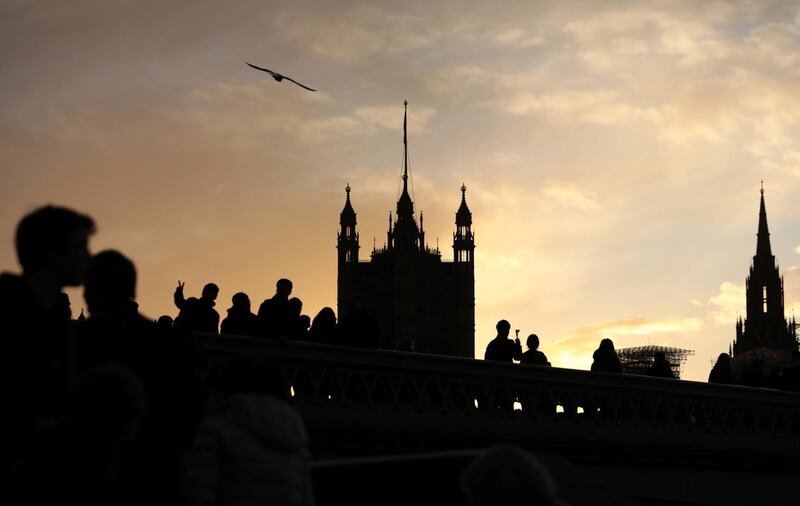 Tourists walk over Westminster Bridge as the sun sets over the Houses of Parliament, in London, Britain November 24, 2017.  REUTERS/Simon Dawson