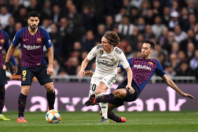 Barcelona's Spanish midfielder Sergio Busquets, right, tackles Real Madrid's Luka Modric. AFP