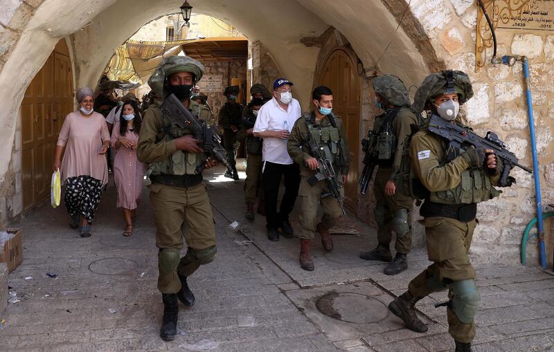 Israeli soldiers and a group of Jewish settlers in protective masks during a weekly guided tour in the old city of Hebron, amid the ongoing coronavirus Covid-19 pandemic in the West Bank.  EPA