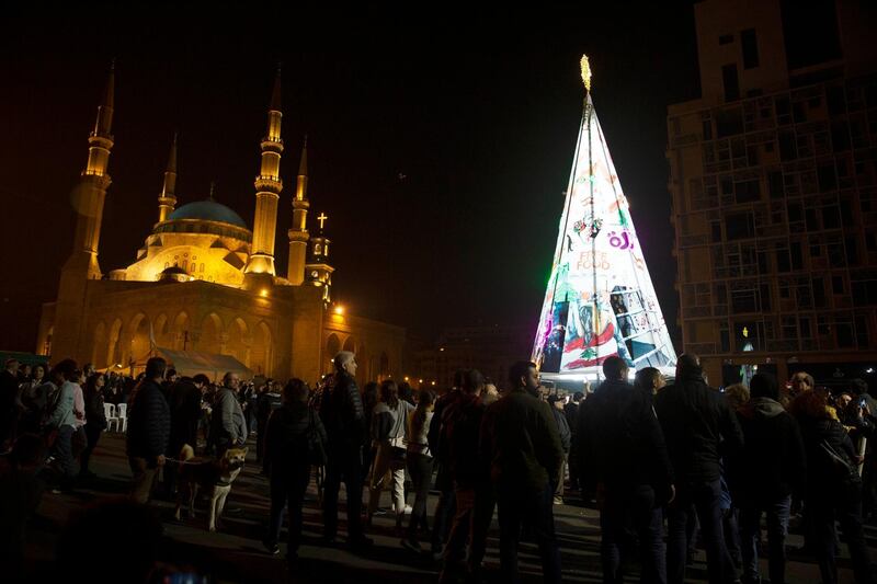 Anti-government protesters gather around their Christmas tree, which incorporates protest iconography and slogans and personal messages from protesters at the base, at a celebration in downtown Beirut. AP Photo