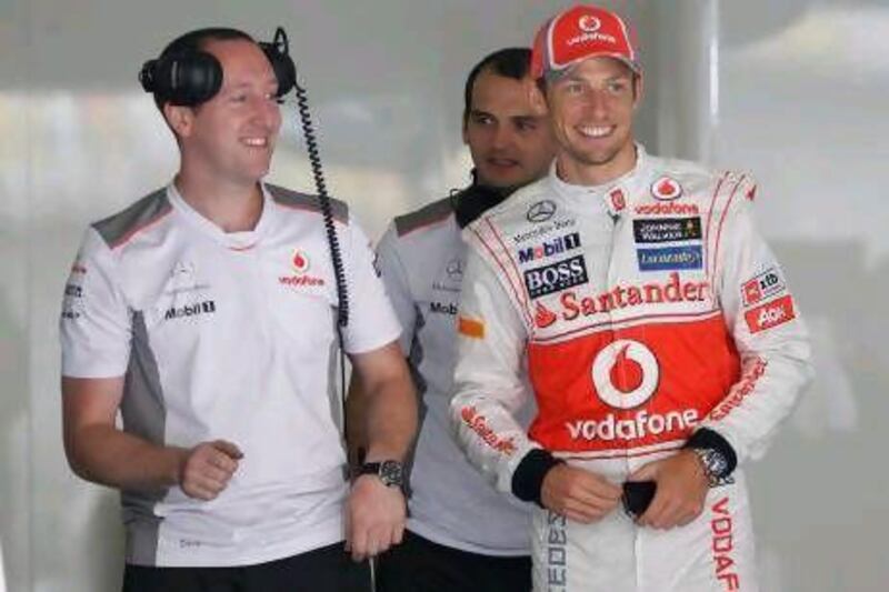 Jenson Button, right, chats with colleagues in the McLaren team garage.