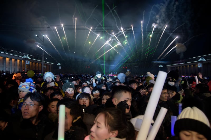 Revellers watch as a fireworks display marks the arrival of the new year following a countdown event on Kim Il Sung Square in Pyongyang on January 1, 2019.  AFP