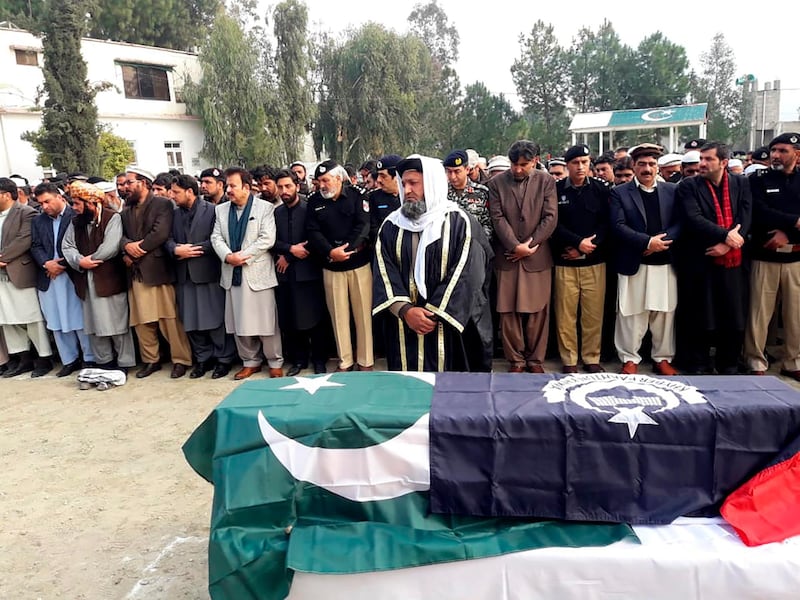 Pakistani villagers offer funeral prayers for killed police officers in Lower Dir, Pakistan, Wednesday, Dec. 18, 2019. Gunmen in Pakistan shot and killed the two policemen on Wednesday who were part of the most recent anti-polio drive in the country's rugged and volatile northwest, officials said. (AP Photo/Muhammad Abdullah Khan)