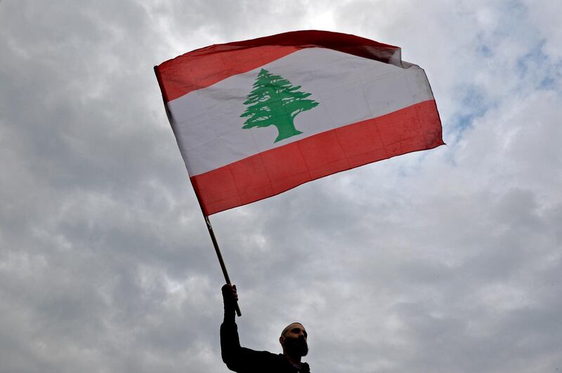 An anti-government protester waves a Lebanese national flag during a protest at Ring Bridge in Beirut, Lebanon. EPA