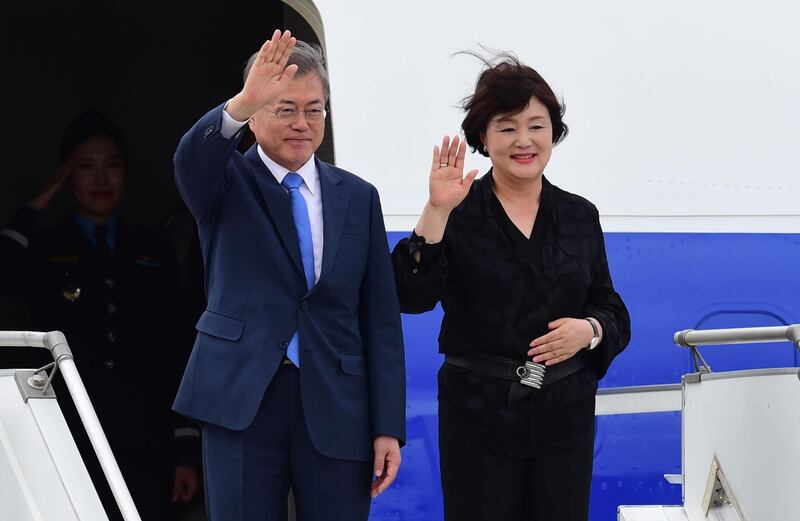 South Korea's President Moon Jae-in  (L) and his wife Kim Jung-sook, wave upon arrival at Ezeiza International airport in Buenos Aires province, on November 29, 2018. Global leaders gather in the Argentine capital for a two-day G20 summit beginning on Friday likely to be dominated by simmering international tensions over trade. / AFP / MARTIN BERNETTI
