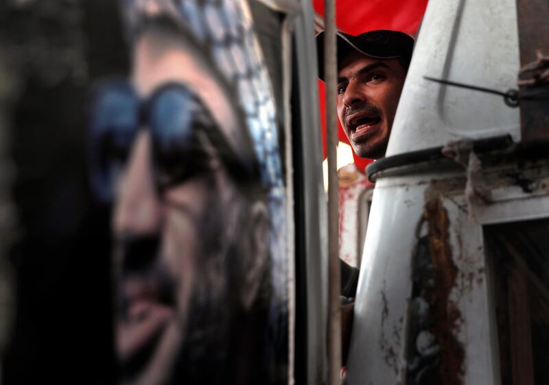 A Palestinian man stands next of a portrait of former Palestinian President Yasser Arafat during a protest at Burj al-Barajneh refugee camp, south of Beirut, Lebanon, Wednesday, January 29, 2020. AP Photo