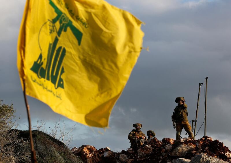 Israeli soldiers stand guard next to cameras at their new position in front of a Hezbollah flag. AP Photo