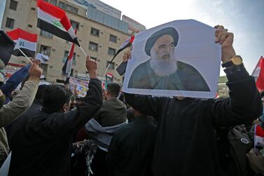 Iraqi supporters of the Hashed Al Shaabi armed network, carrying a pictures of the country's top Shiite cleric, Grand Ayatollah Ali Sistani, demonstrate in Tahrir Square on Thursday. AFP