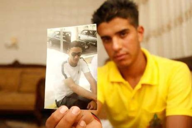 Ahmad al-Nabhan holds a portrait of his cousin Hosam al-Nabhan who was shot dead last week during his celebration with friends for his graduation from the school, in the town of al-Shajarah, north Jordan on August 2010. (Salah Malkawi for The National)