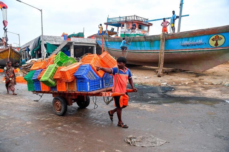 A fisherman pulls a handcart filled with crates towards inland ahead of a cyclonic storm that may hit the North Maharashtra and Gujarat coast, at the Madh fishing village, in the north western coast of Mumbai on June 2, 2020. / AFP / INDRANIL MUKHERJEE
